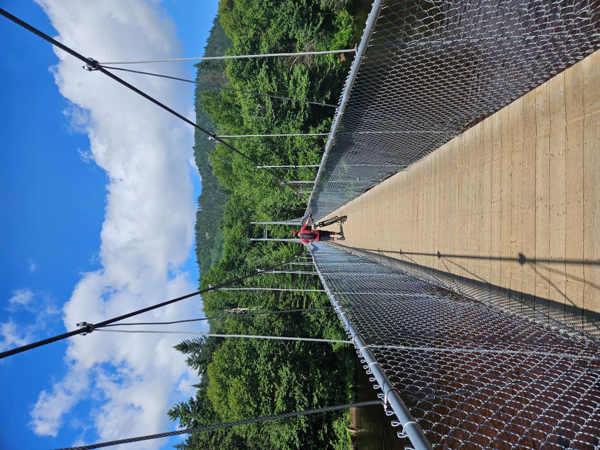 Author walking their bike across the bridge at Bras-du-Nord as instructed